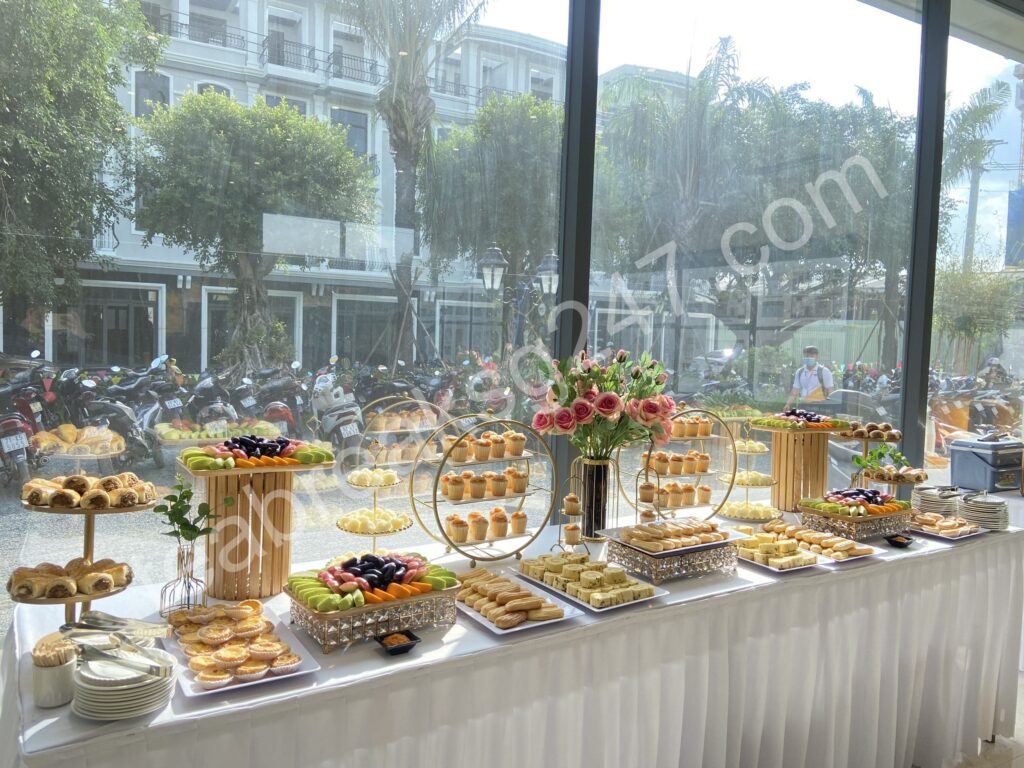 Bàn tiệc teabreak hiện đại với bánh ngọt, nước ép và không gian bài trí sang trọng.