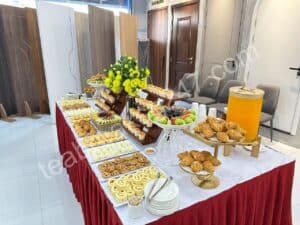 Bàn tiệc teabreak hiện đại với bánh ngọt, nước ép và không gian bài trí sang trọng.